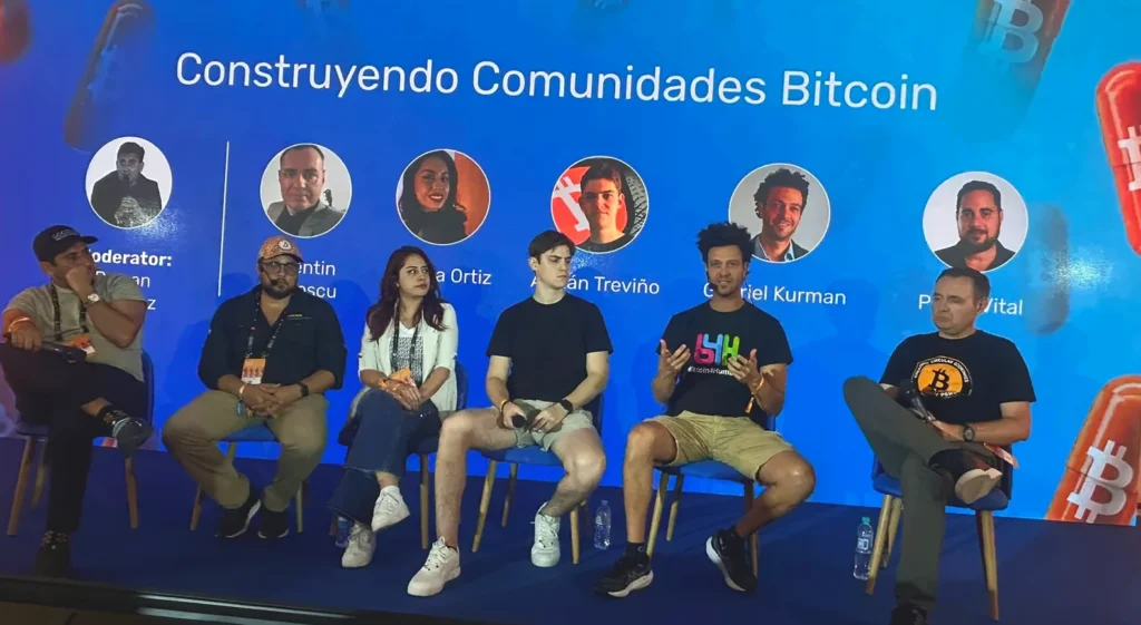 Panel sobre comunidades Bitcoin en un evento de innovación y regulación, con Pedro Vital al extremo derecho.
